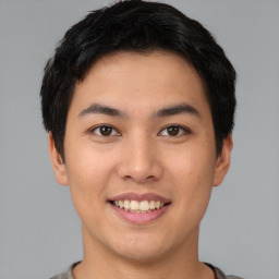 Joyful asian young-adult male with short  brown hair and brown eyes