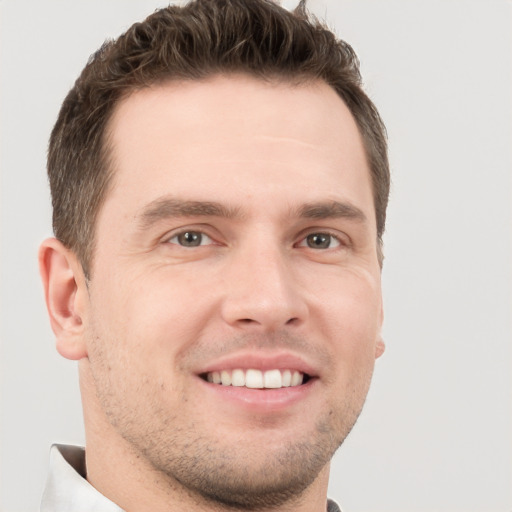 Joyful white young-adult male with short  brown hair and grey eyes