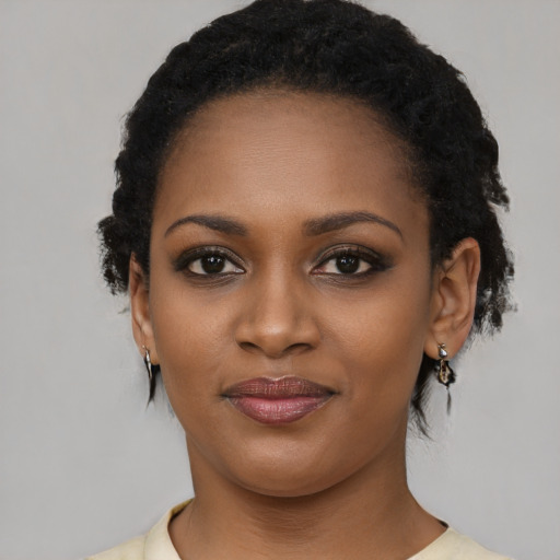 Joyful black young-adult female with short  black hair and brown eyes