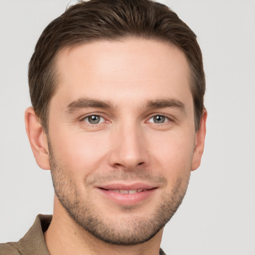 Joyful white young-adult male with short  brown hair and grey eyes