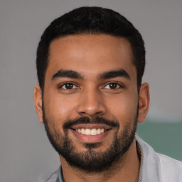 Joyful latino young-adult male with short  black hair and brown eyes