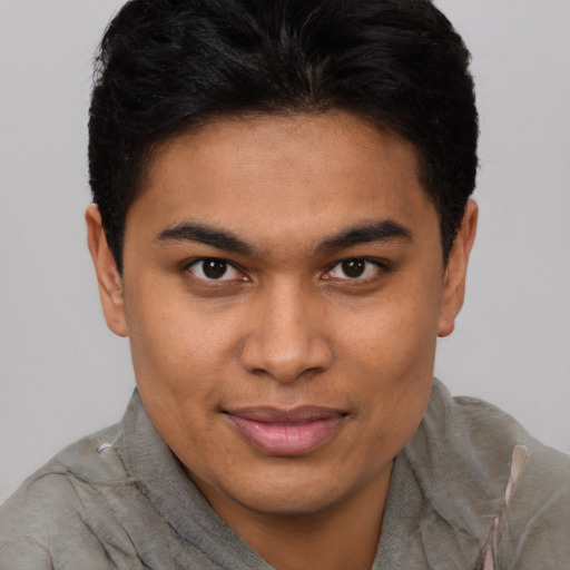 Joyful latino young-adult male with short  brown hair and brown eyes