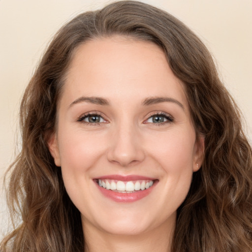 Joyful white young-adult female with long  brown hair and green eyes