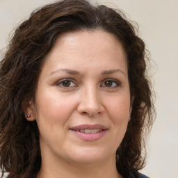 Joyful white adult female with long  brown hair and brown eyes