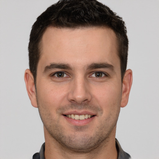 Joyful white young-adult male with short  brown hair and brown eyes