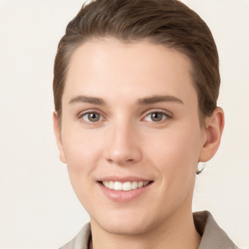 Joyful white young-adult female with short  brown hair and grey eyes