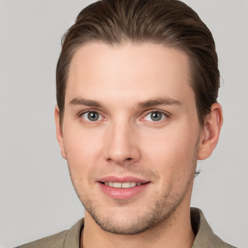 Joyful white young-adult male with short  brown hair and grey eyes