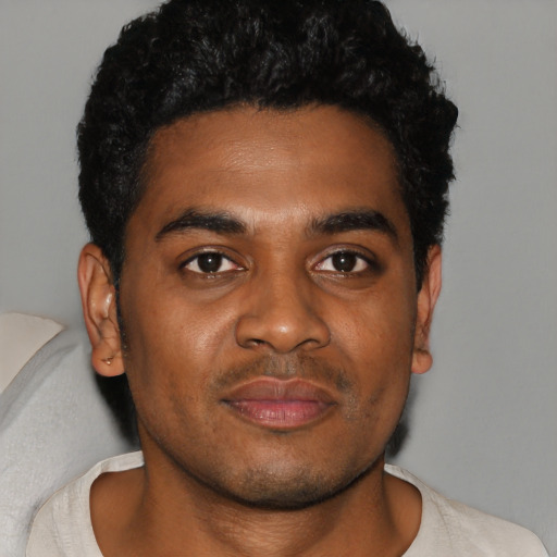 Joyful black young-adult male with short  black hair and brown eyes