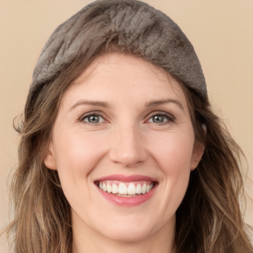 Joyful white young-adult female with long  brown hair and grey eyes