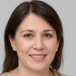 Joyful white adult female with medium  brown hair and grey eyes