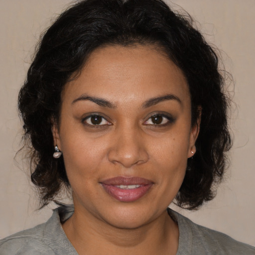 Joyful black young-adult female with medium  brown hair and brown eyes