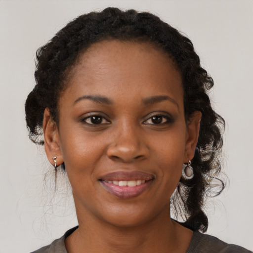 Joyful black young-adult female with medium  brown hair and brown eyes