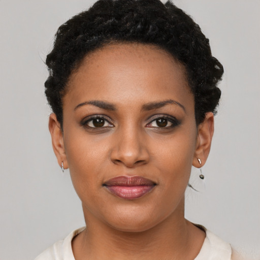 Joyful black young-adult female with short  black hair and brown eyes