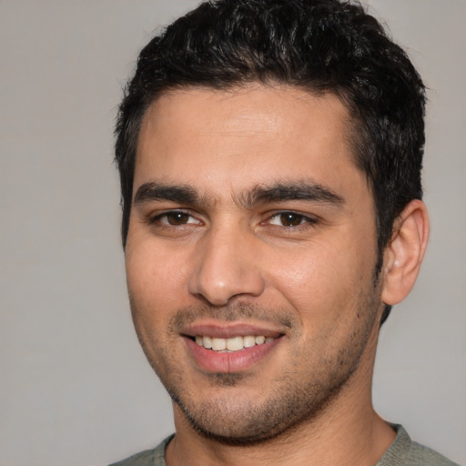 Joyful white young-adult male with short  black hair and brown eyes