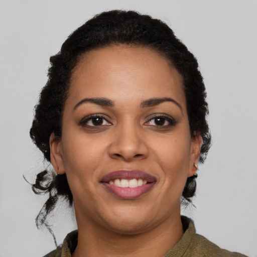 Joyful black young-adult female with short  black hair and brown eyes