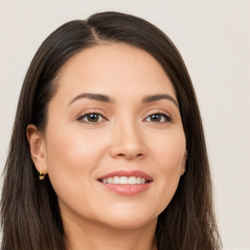 Joyful white young-adult female with long  brown hair and brown eyes