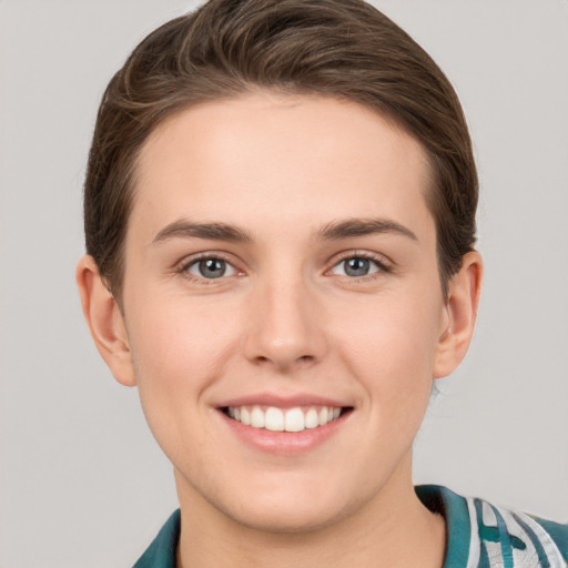 Joyful white young-adult female with short  brown hair and grey eyes