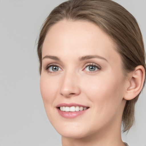 Joyful white young-adult female with medium  brown hair and grey eyes