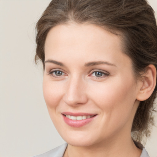 Joyful white young-adult female with medium  brown hair and grey eyes