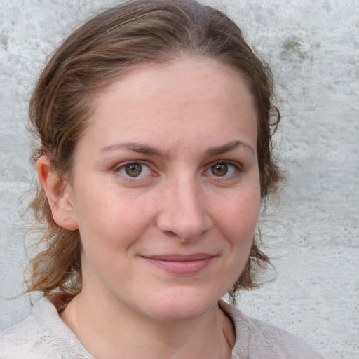 Joyful white young-adult female with medium  brown hair and blue eyes