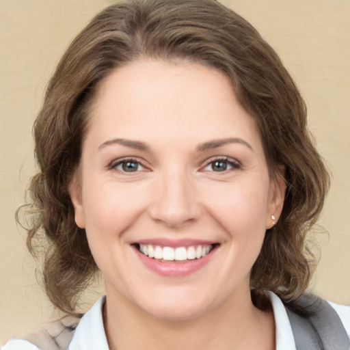 Joyful white young-adult female with medium  brown hair and green eyes