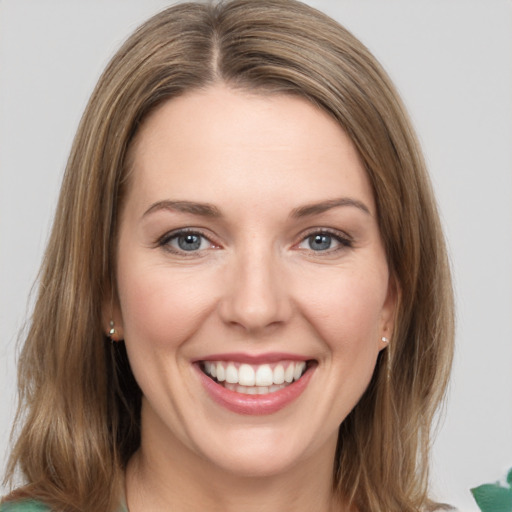 Joyful white young-adult female with medium  brown hair and green eyes