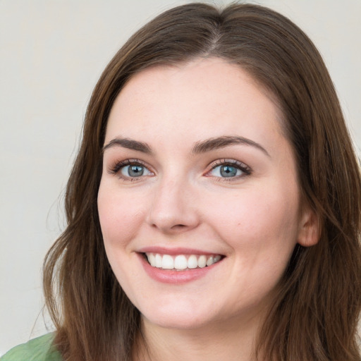 Joyful white young-adult female with long  brown hair and green eyes