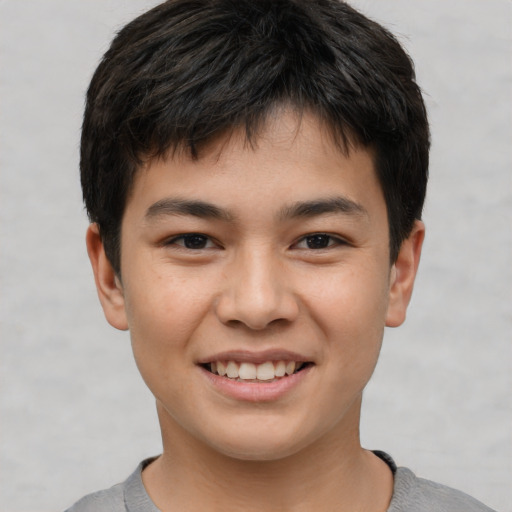 Joyful asian child male with short  brown hair and brown eyes