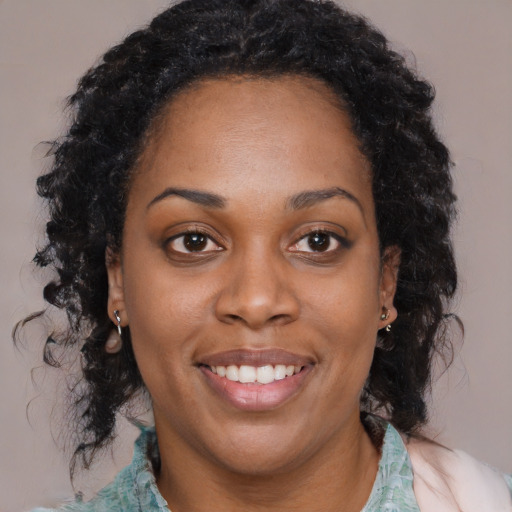 Joyful black adult female with long  black hair and brown eyes