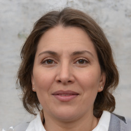 Joyful white adult female with medium  brown hair and grey eyes