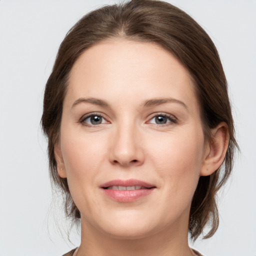 Joyful white young-adult female with medium  brown hair and grey eyes