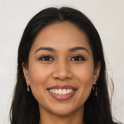 Joyful latino young-adult female with long  brown hair and brown eyes