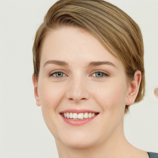 Joyful white young-adult female with short  brown hair and green eyes