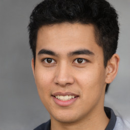 Joyful latino young-adult male with short  brown hair and brown eyes