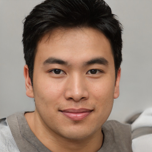 Joyful asian young-adult male with short  brown hair and brown eyes