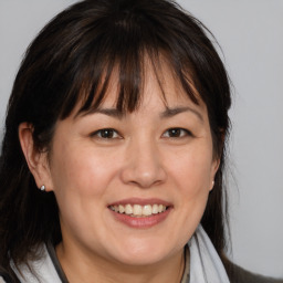 Joyful white adult female with medium  brown hair and brown eyes