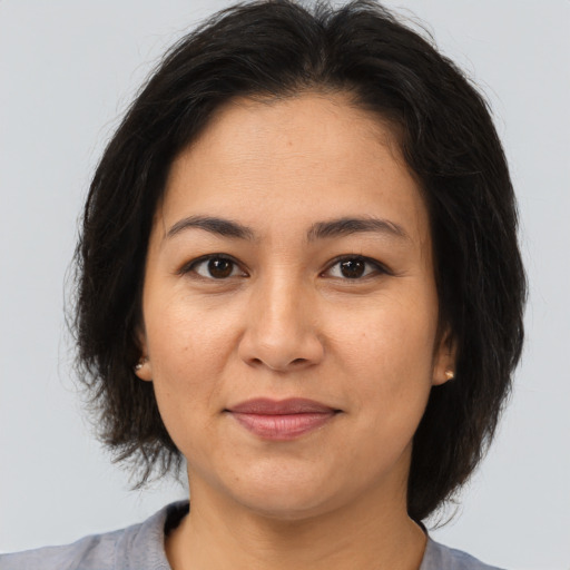 Joyful asian adult female with medium  brown hair and brown eyes