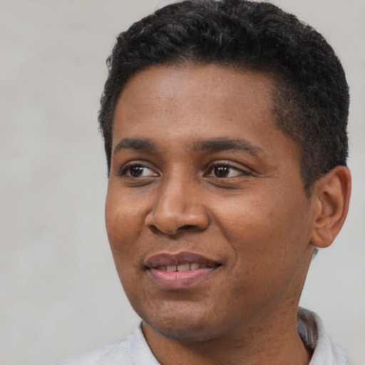 Joyful black young-adult male with short  black hair and brown eyes