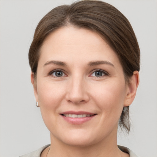 Joyful white young-adult female with short  brown hair and grey eyes