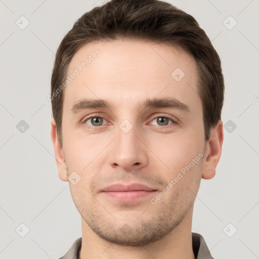 Joyful white young-adult male with short  brown hair and grey eyes