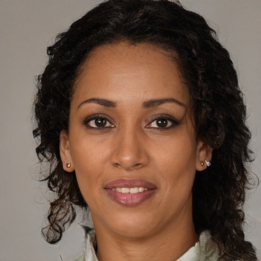 Joyful black adult female with long  brown hair and brown eyes
