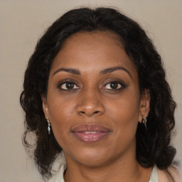 Joyful black adult female with long  brown hair and brown eyes