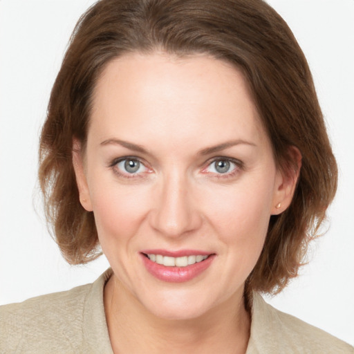 Joyful white young-adult female with medium  brown hair and grey eyes