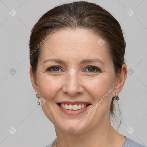 Joyful white adult female with medium  brown hair and grey eyes