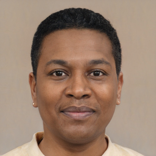 Joyful black young-adult male with short  black hair and brown eyes