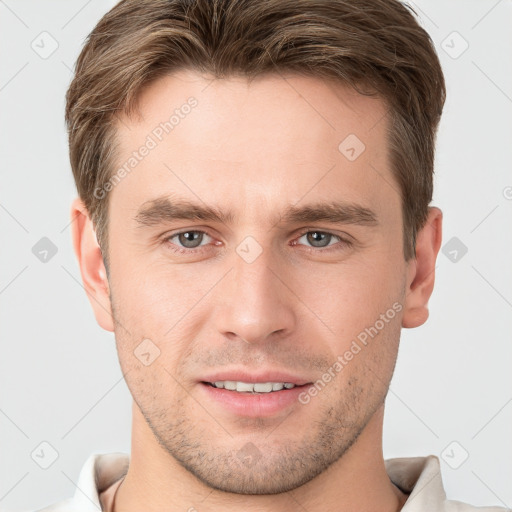 Joyful white young-adult male with short  brown hair and grey eyes