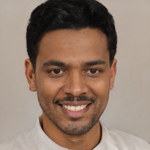 Joyful latino young-adult male with short  black hair and brown eyes
