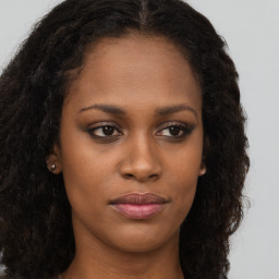 Joyful black young-adult female with long  brown hair and brown eyes