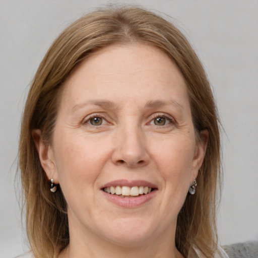 Joyful white adult female with medium  brown hair and grey eyes