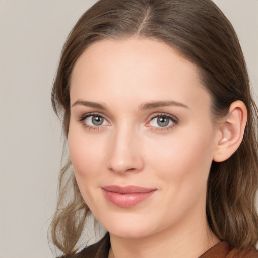 Joyful white young-adult female with long  brown hair and grey eyes